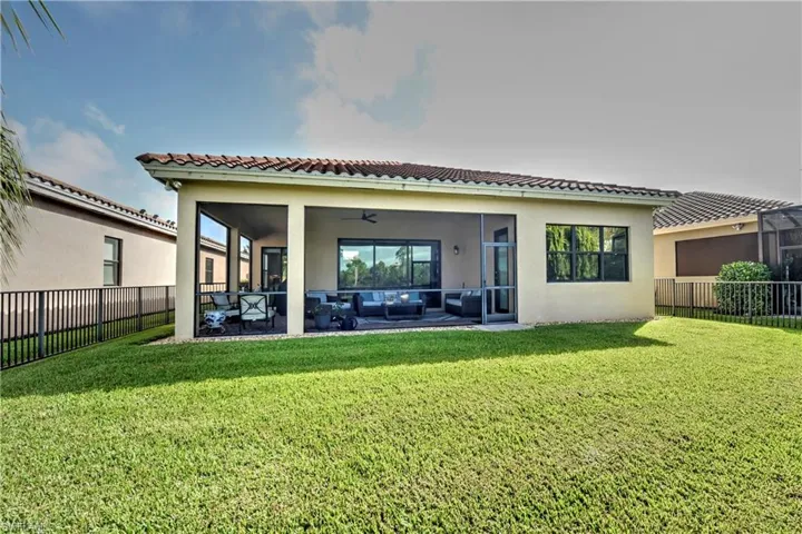 Rear view of house featuring outdoor lounge area, ceiling fan, a patio area, and a yard