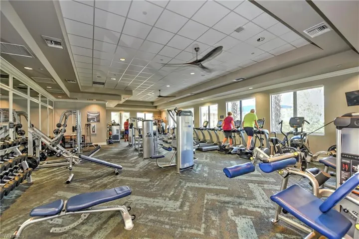 Workout area featuring a drop ceiling, carpet floors, and ornamental molding