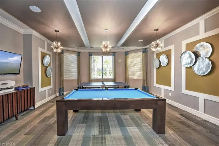 Recreation room featuring a chandelier, dark hardwood / wood-style flooring, ornamental molding, and pool table