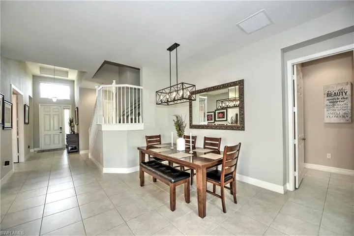 Tiled dining room featuring an inviting chandelier
