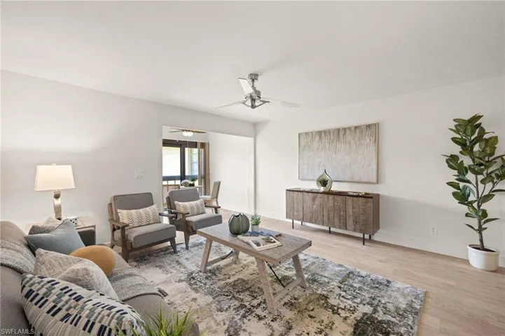 Living area featuring light wood-style flooring, ceiling fan, and baseboards