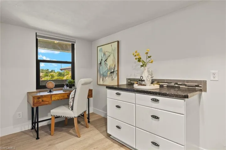 Office with light wood-style floors and baseboards