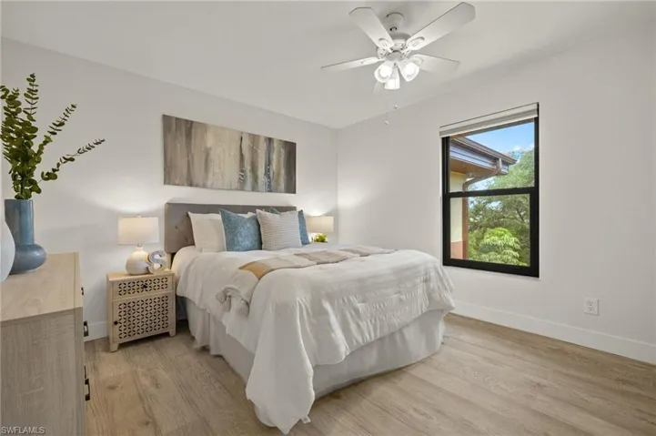 Bedroom featuring light wood-style flooring, baseboards, and a ceiling fan