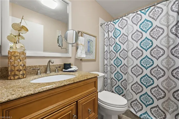 Bathroom with vanity, toilet, and a shower with shower curtain