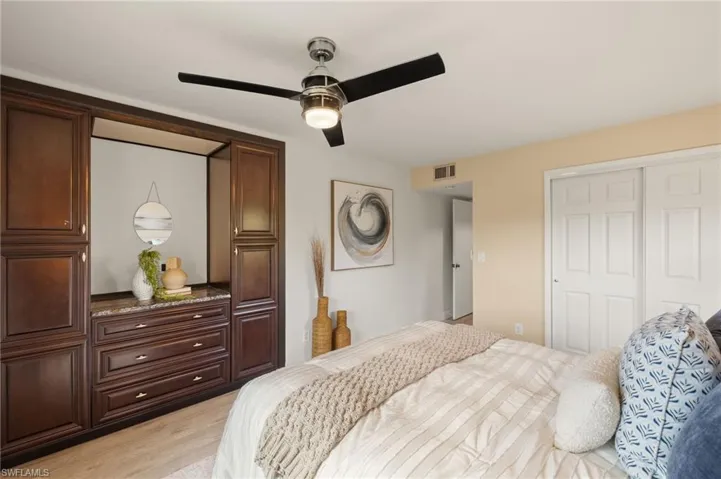 Bedroom with a closet, light wood-style floors, and ceiling fan