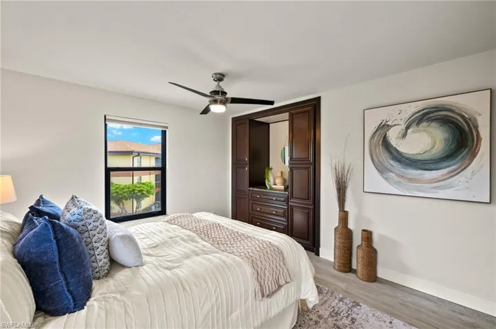 Bedroom featuring light wood-style floors, baseboards, and ceiling fan