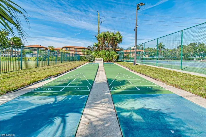 View of community with a tennis court and shuffleboard