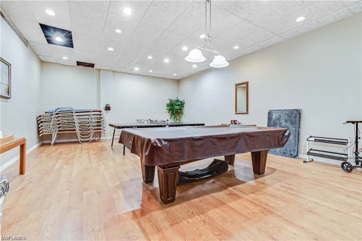 Recreation room with light wood-type flooring, baseboards, a drop ceiling, recessed lighting, and pool table