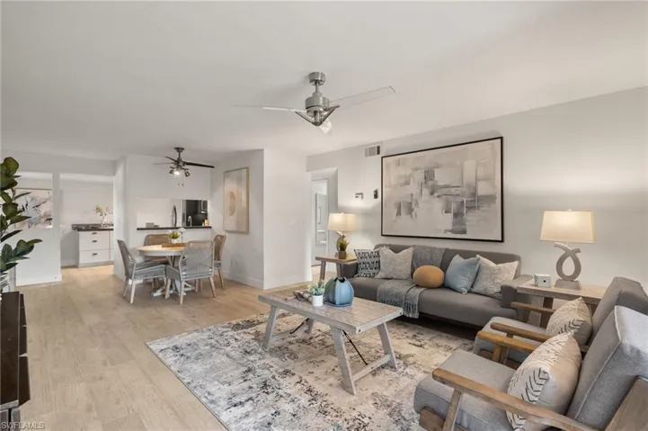 Living room featuring a ceiling fan, light wood-type flooring, and baseboards