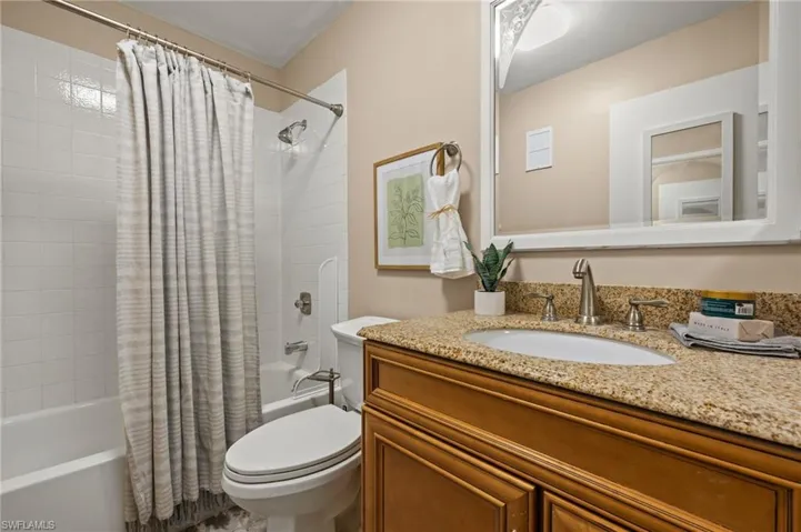 Full bathroom featuring vanity, shower / bath combination with curtain, and toilet
