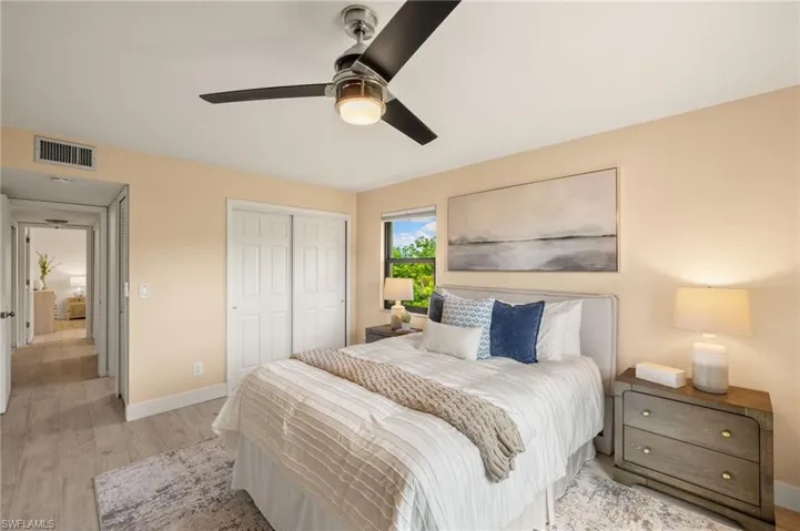 Bedroom with light wood-type flooring, baseboards, a closet, and ceiling fan