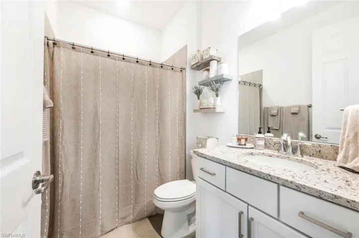 Bathroom with vanity, toilet, and a shower