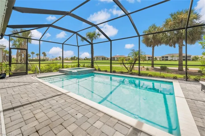 View of swimming pool featuring a patio area, an in ground hot tub, and a lanai
