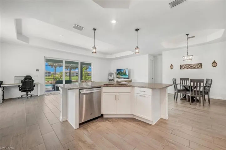 Kitchen featuring white cabinets, a raised ceiling, and stainless steel appliances and gas range