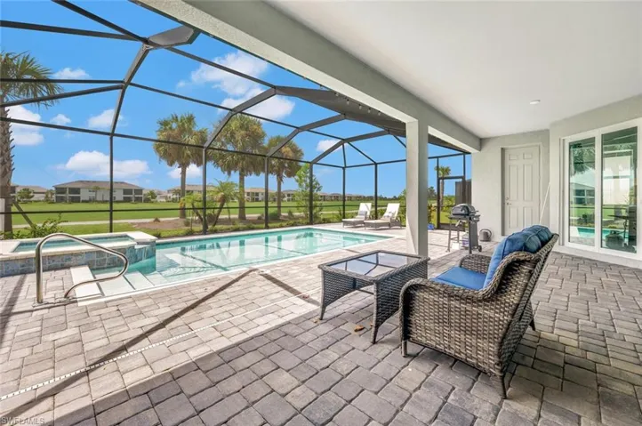 View of swimming pool featuring a lanai, hot tub, lanai with half bath outside for guests at the pool
