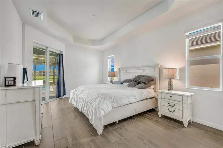 Bedroom with a tray ceiling, access to pool and gorgeous tile flooring