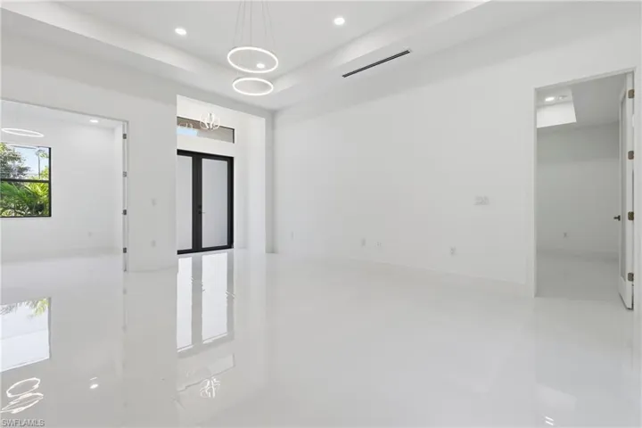 Unfurnished room featuring french doors, a tray ceiling, and suspended lighting