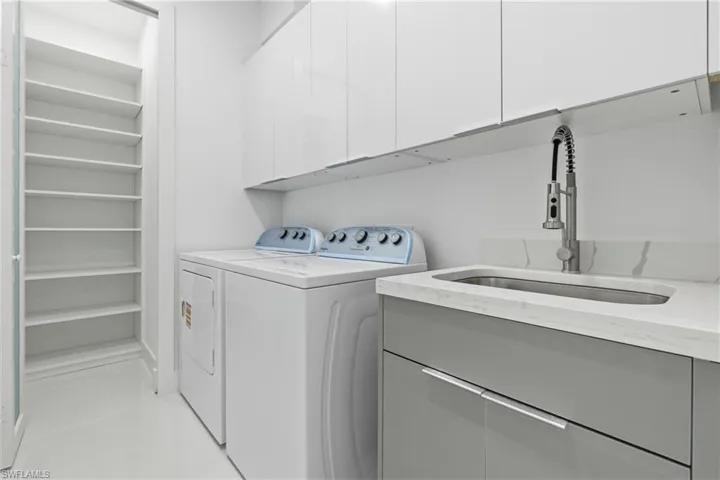 Laundry room featuring independent washer and dryer and cabinet space