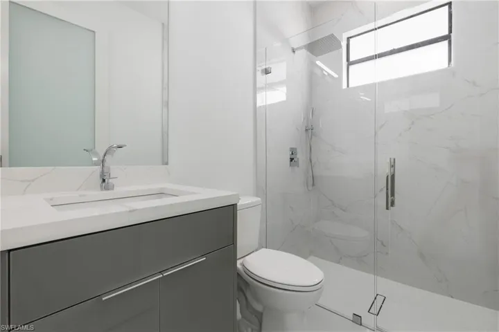Full bath with vanity and a marble finish shower
