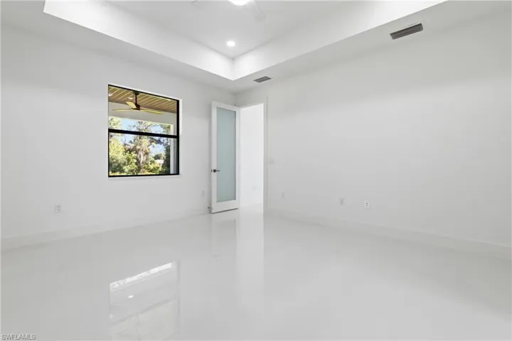Unfurnished room with a tray ceiling, a ceiling fan, and recessed lighting