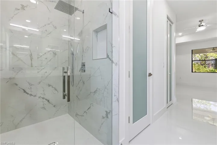 Bathroom featuring a marble finish shower, ceiling fan, and recessed lighting