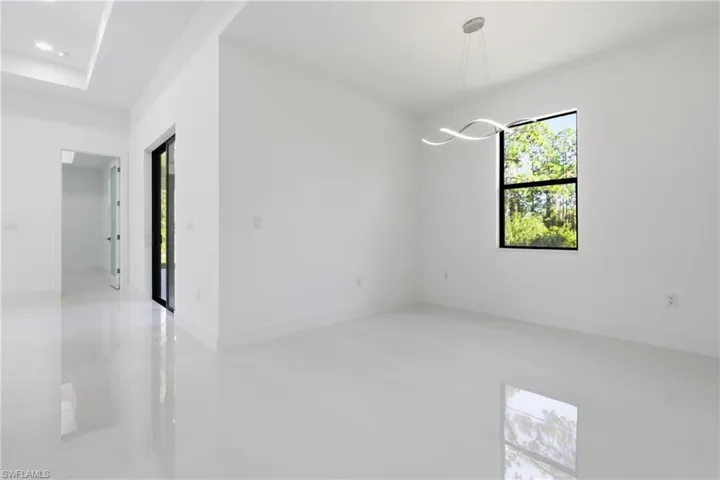 Empty room with suspended lighting and baseboards