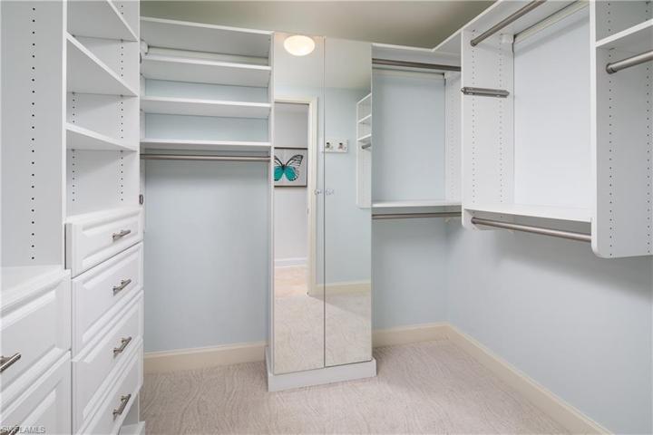 His and Hers Walk in closets with Custom built in shelving, drawers, shoe rack, and hidden hamper.