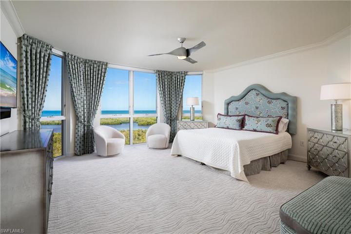 Primary Suite Entry Hall View into Primary Bedroom. Direct Western Facing Gulf of Mexico and Inner Clam Bay Views visible upon immediate entry into Primary Bedroom.