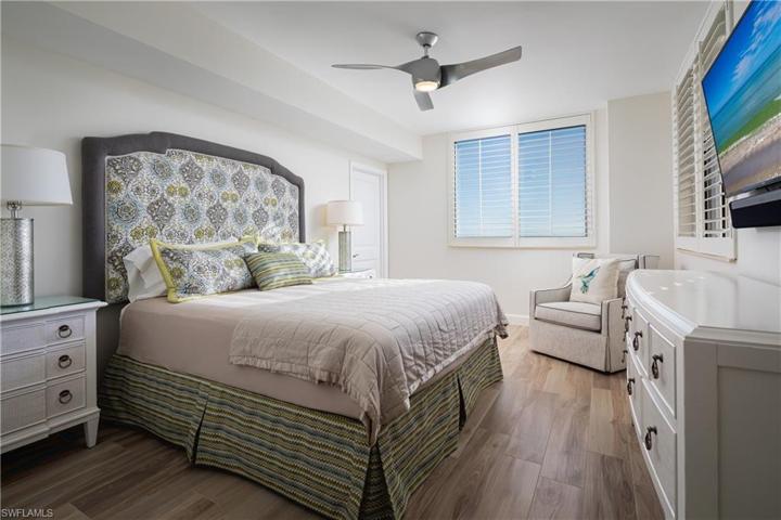 En Suite Guest Bedroom with King Sized Bed, Walk-in Closest, Custom Upholstered Headboard. Expansive Pelican Bay and Gulf of Mexico Views from Multiple Vantage Points within Guest Bedroom.