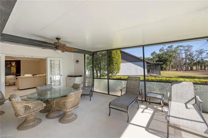 Sunroom / solarium featuring outdoor dining area and a ceiling fan