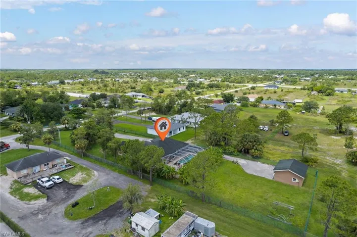 Aerial view of property and surrounding area featuring nearby suburban area