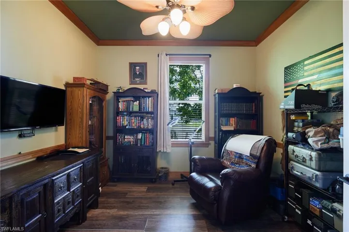 Sitting room with crown molding, ceiling fan, and dark wood-type flooring