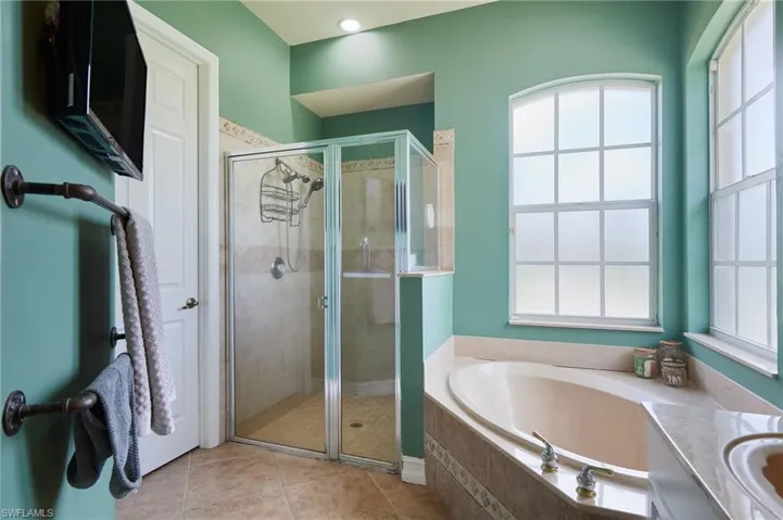 Full bath with a garden tub, a shower stall, and tile patterned flooring