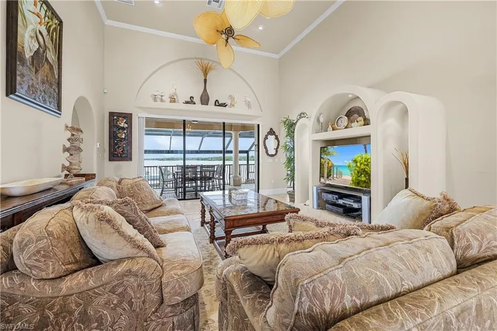 Spacious living area featuring a vaulted ceiling and an integrated entertainment center with built-in shelving