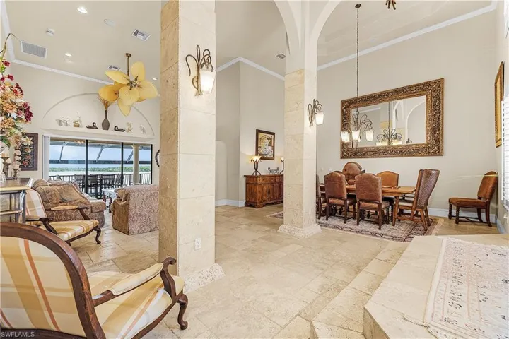 Spacious living area featuring stone-finish flooring, vaulted ceilings, and archway detailing