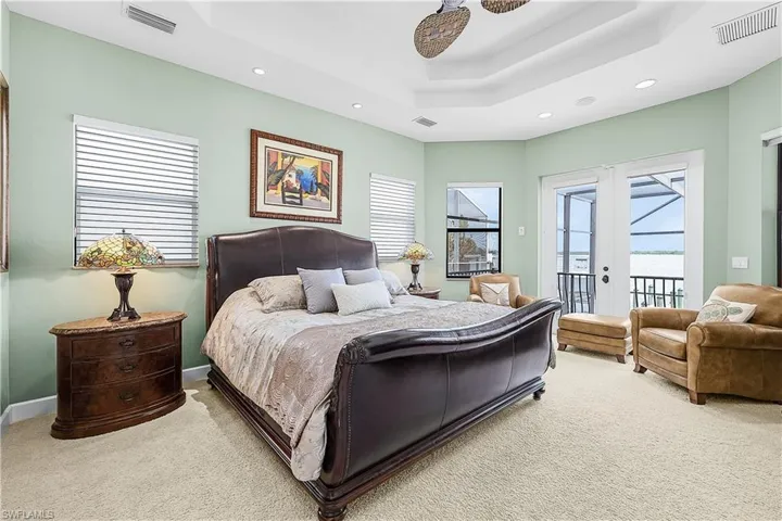 Bedroom with light green walls and beige carpet flooring