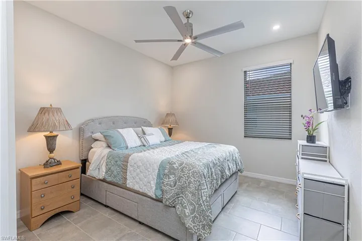 Bedroom with ceiling fan, light tile patterned flooring, and recessed lighting