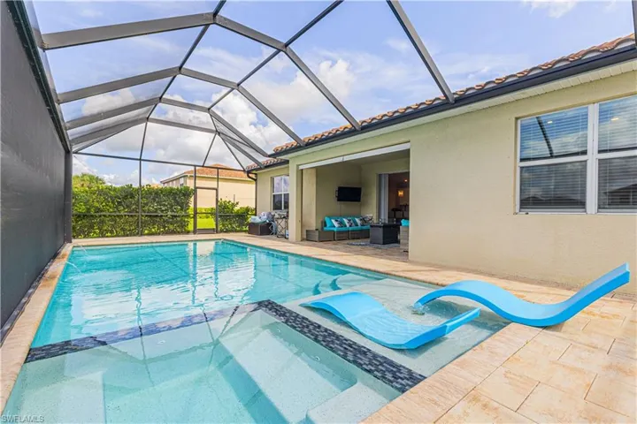 Relaxing pool / spa with a sunroom, glass enclosure, a patio, and an outdoor lounge area