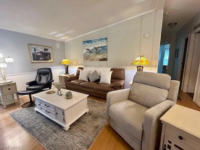 Living room featuring bamboo wood-style floors and a wainscoted wall