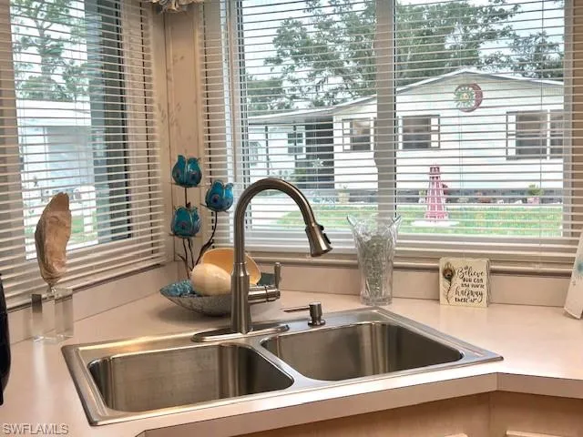 Kitchen view of a sink and light countertops