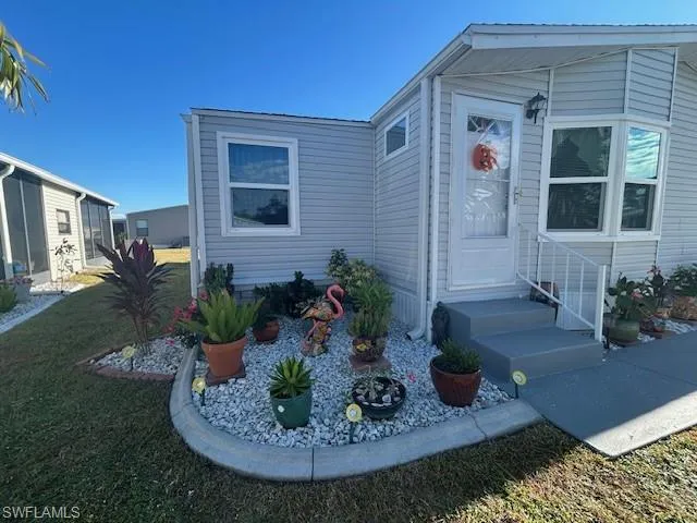 View of exterior entry featuring a lawn