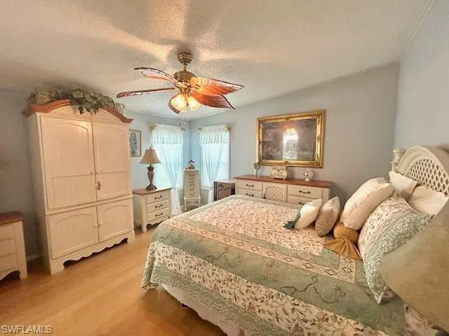 Bedroom featuring bamboo wood-type flooring, ceiling fan, and a textured ceiling