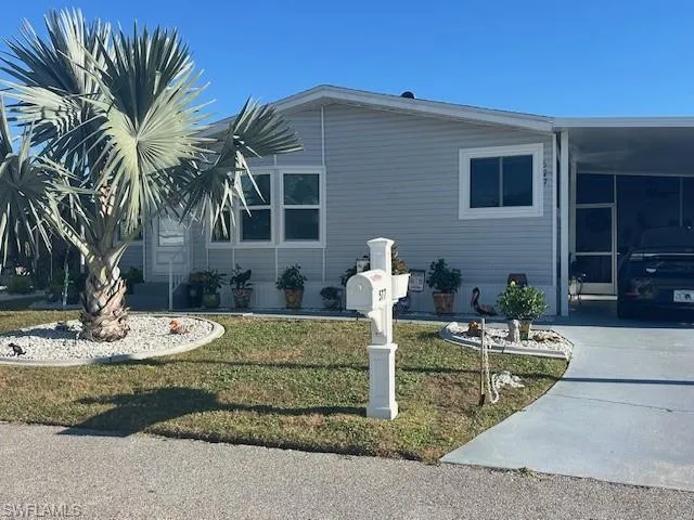 View of home's exterior featuring a yard, an attached carport, and a sunroom