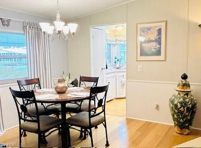 Dining area featuring bamboo wood finished floors, a chandelier, and ornamental molding