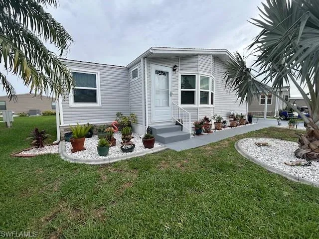 Manufactured / mobile home with a front lawn and entry steps