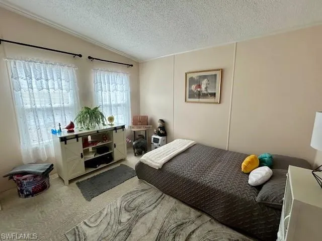 Carpeted bedroom featuring a decorative wall