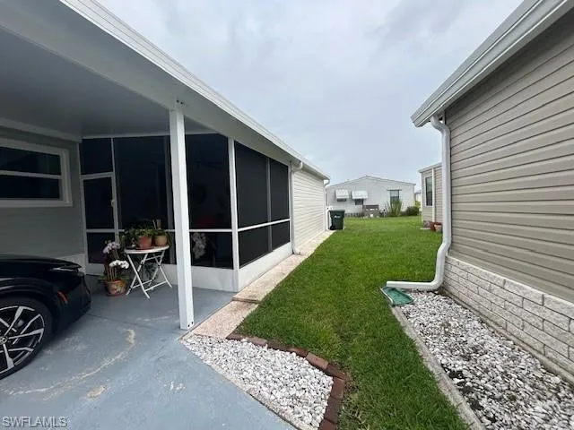 View of green lawn featuring a sunroom