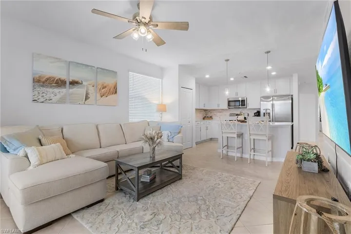 Living room featuring ceiling fan, a healthy amount of sunlight, and light tile patterned flooring