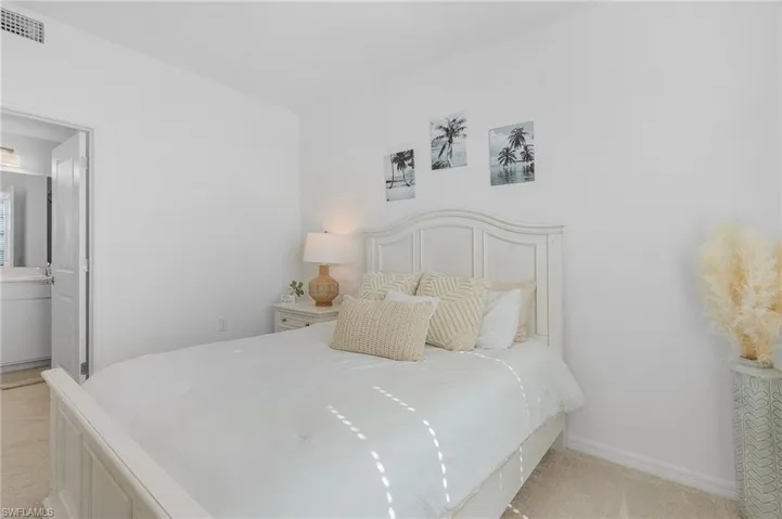 Carpeted bedroom featuring ensuite bathroom
