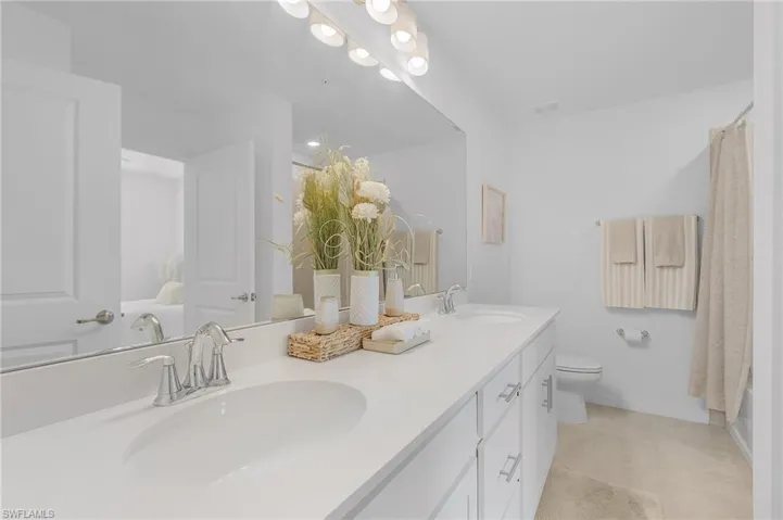 Bathroom featuring tile patterned floors, vanity, and toilet